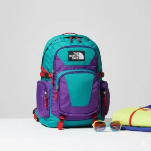 A bright teal and purple vintage north face backpack representing the colorful 90s era design.