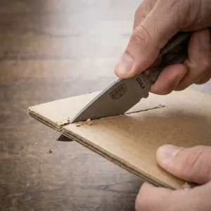 Using a fixed blade edc knife to cleanly slice through a thick cardboard shipping box.